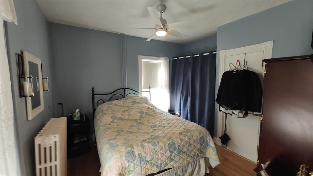 46 Irving Street Everett, MA 02149 - Photo 14 of 42 a bed room with a bed closet and a flat tv screen