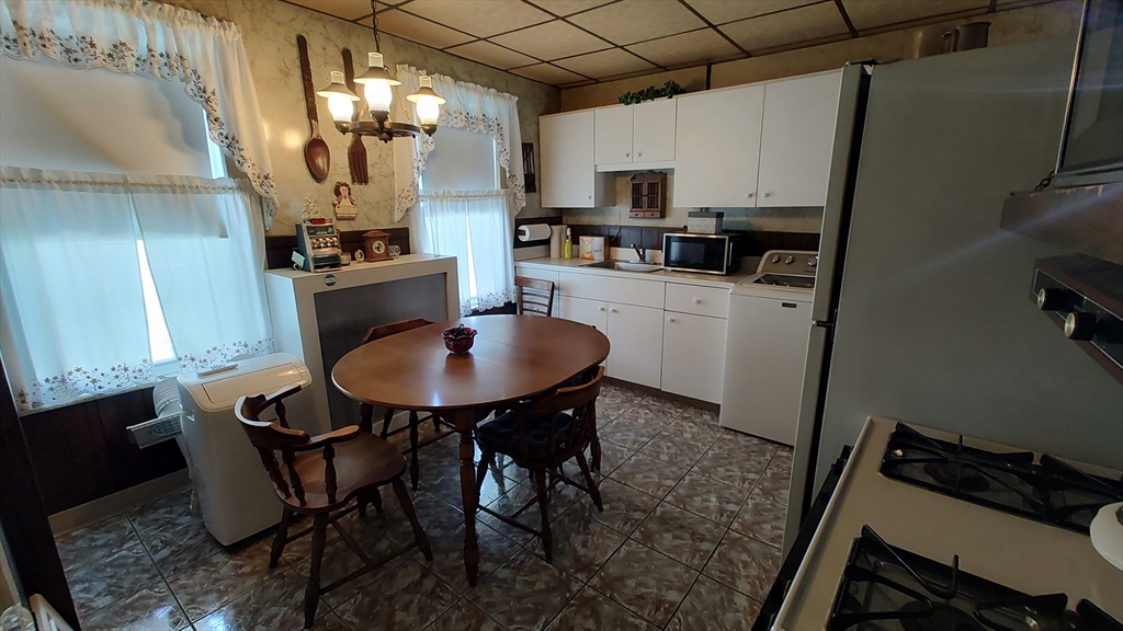 46 Irving Street Everett, MA 02149 - Photo 23 of 42 a kitchen with stainless steel appliances a table chairs and a refrigerator