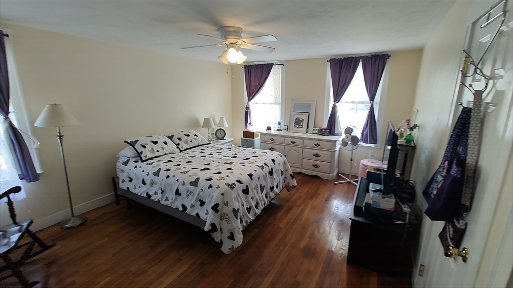 46 Irving Street Everett, MA 02149 - Photo 31 of 42 a bedroom with a bed a large window and wooden floor