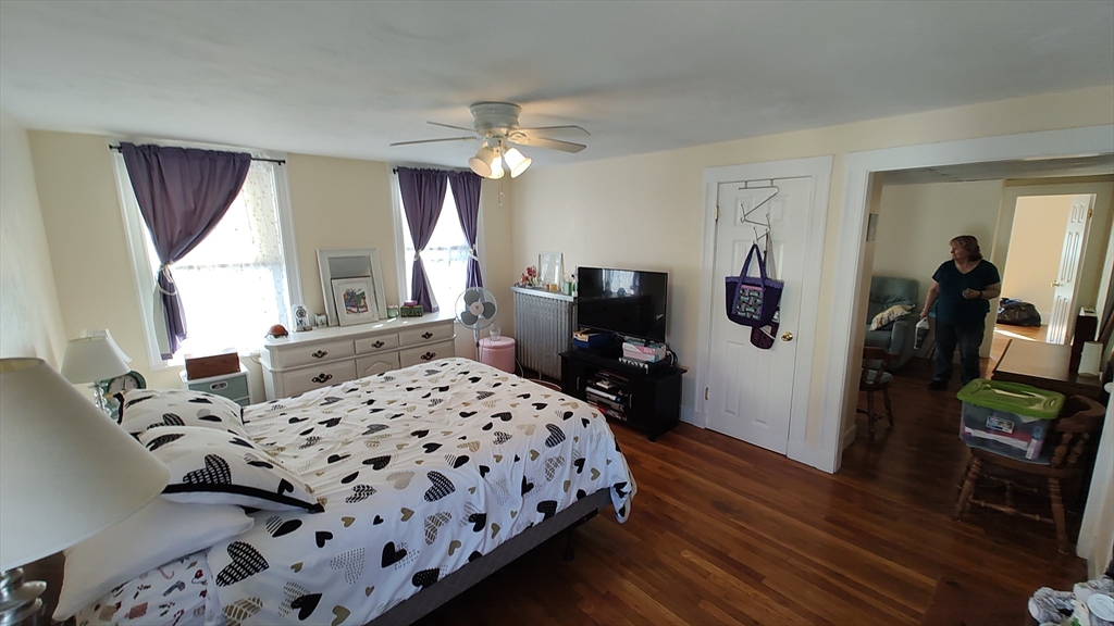 46 Irving Street Everett, MA 02149 - Photo 32 of 42 a bedroom with a bed and wooden floor