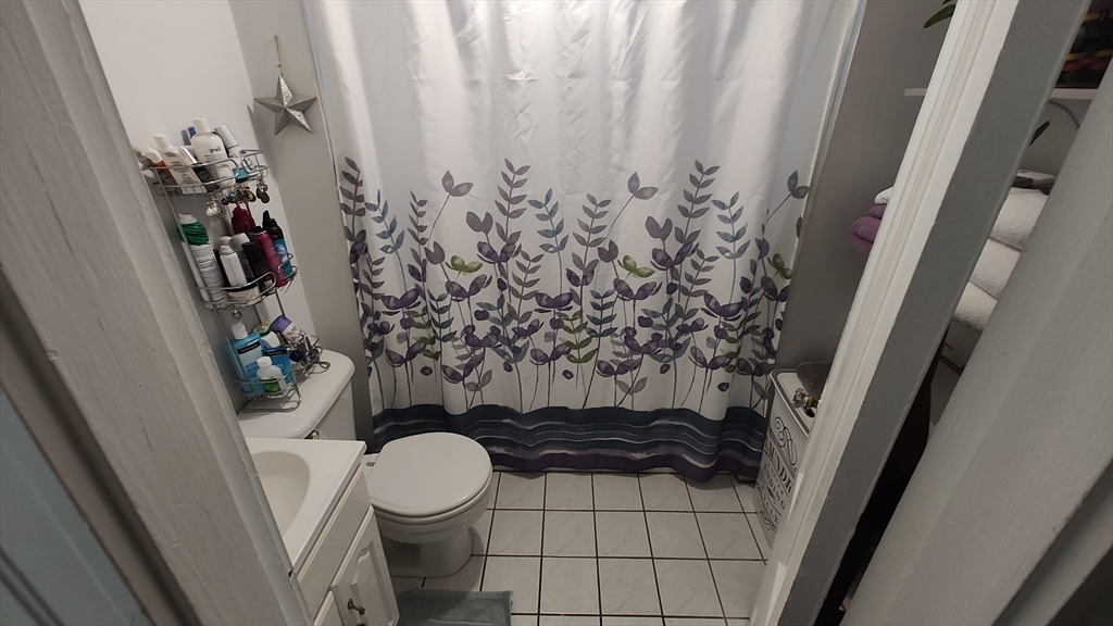 46 Irving Street Everett, MA 02149 - Photo 35 of 42 a bathroom with a toilet and a shower curtain