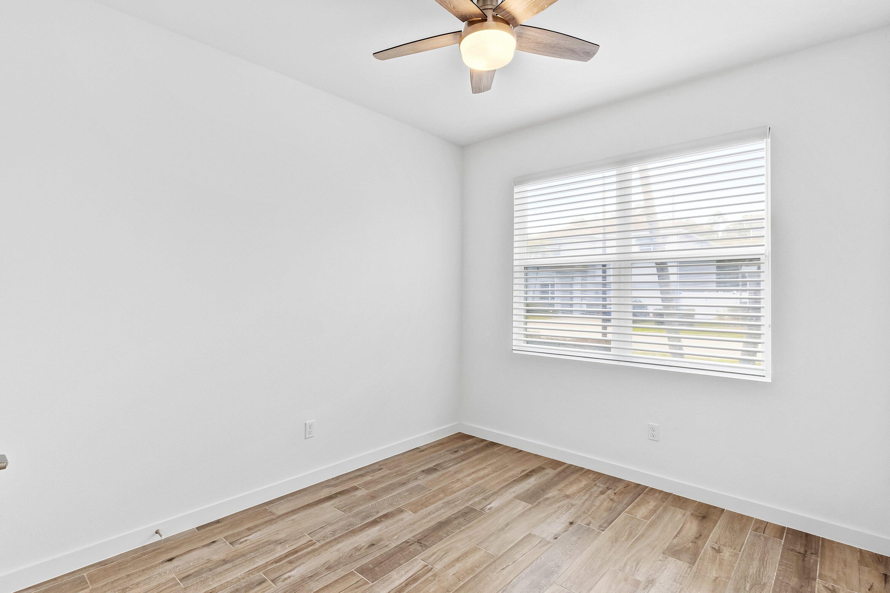 18446 Claybrook Street Jupiter, FL 33458 - Photo 15 of 25 a view of an empty room with wooden floor and a window