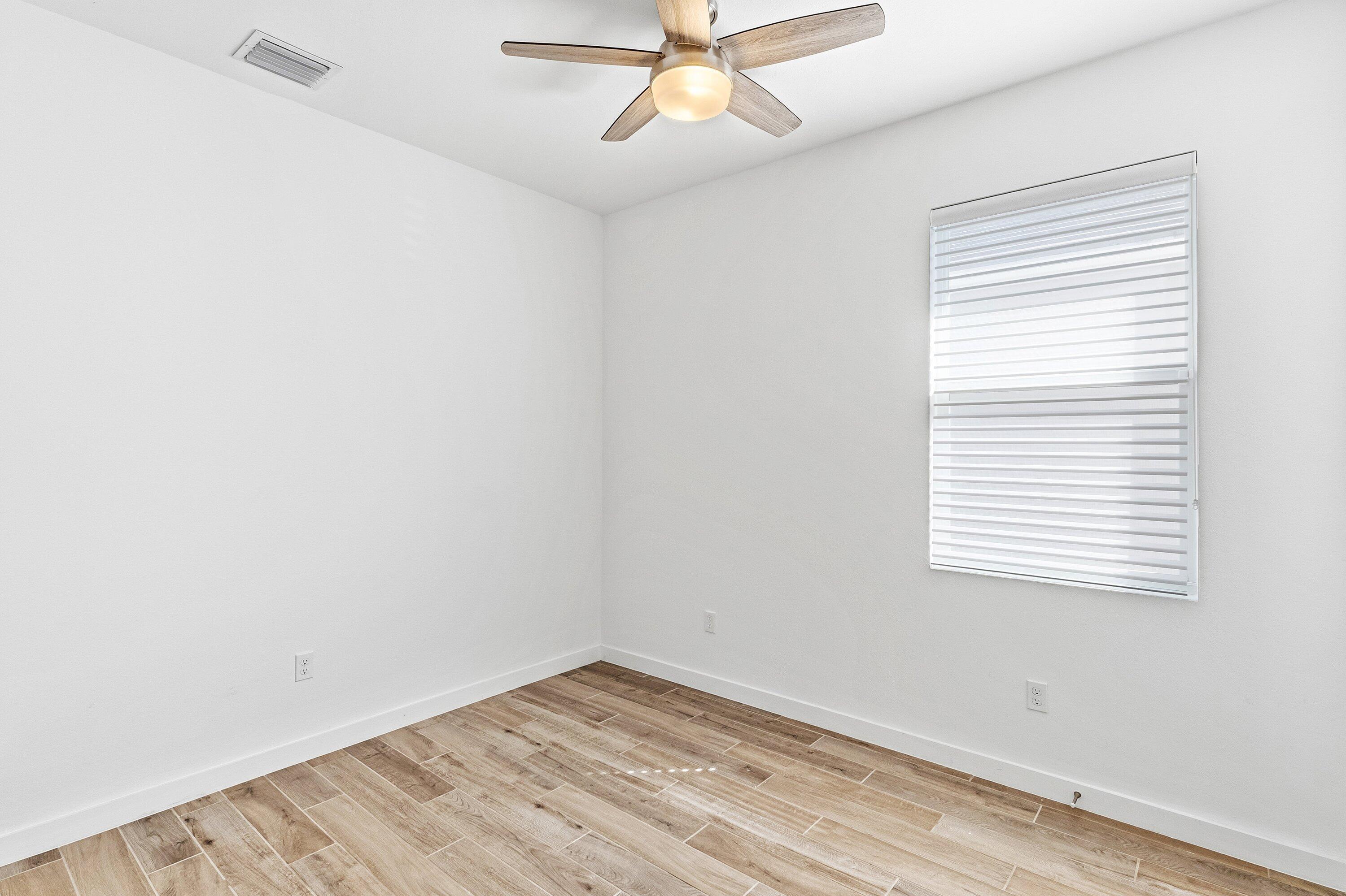18446 Claybrook Street Jupiter, FL 33458 - Photo 17 of 25 an empty room with a window and a fan