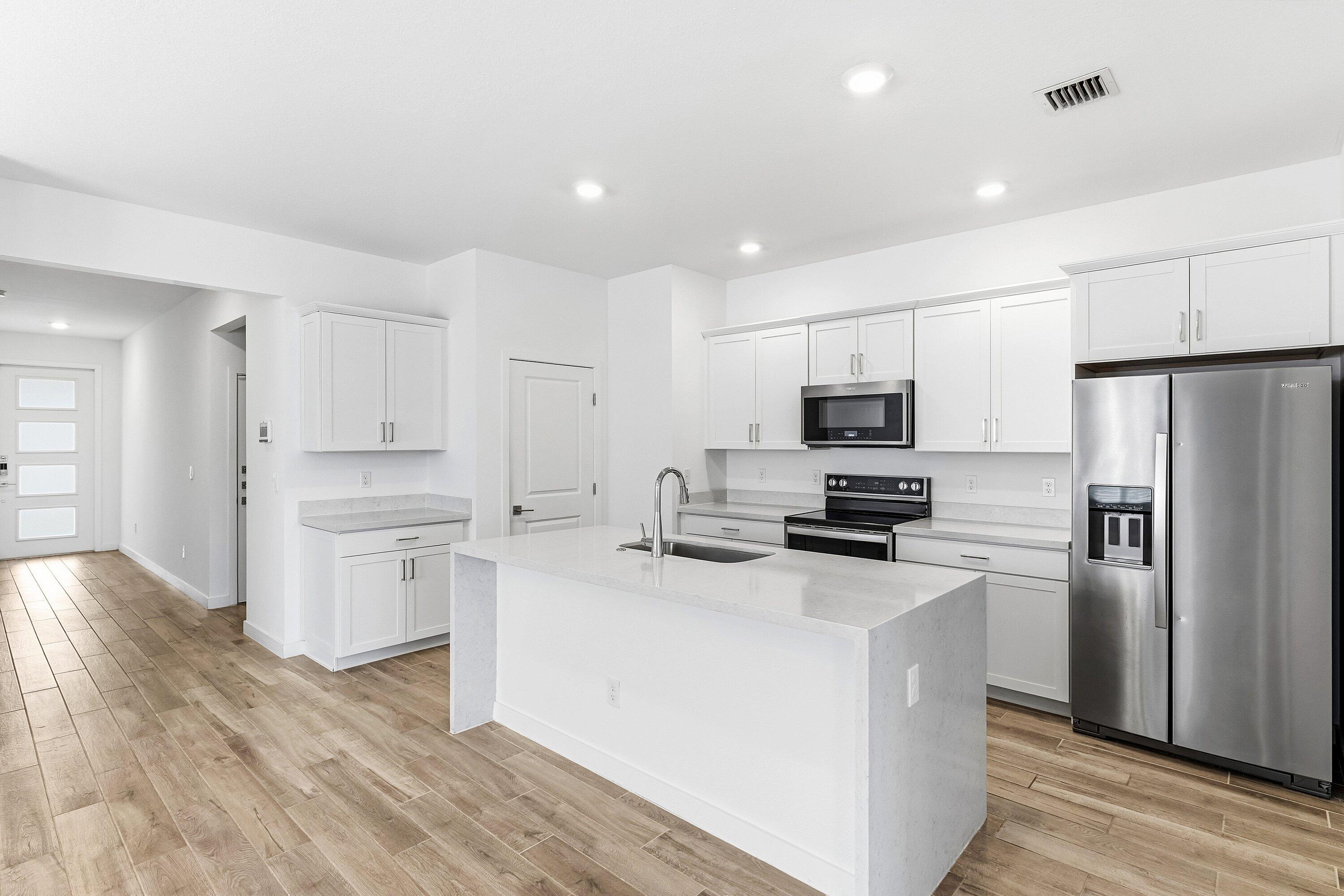 18446 Claybrook Street Jupiter, FL 33458 - Photo 4 of 25 a kitchen with stainless steel appliances a refrigerator stove microwave and cabinets