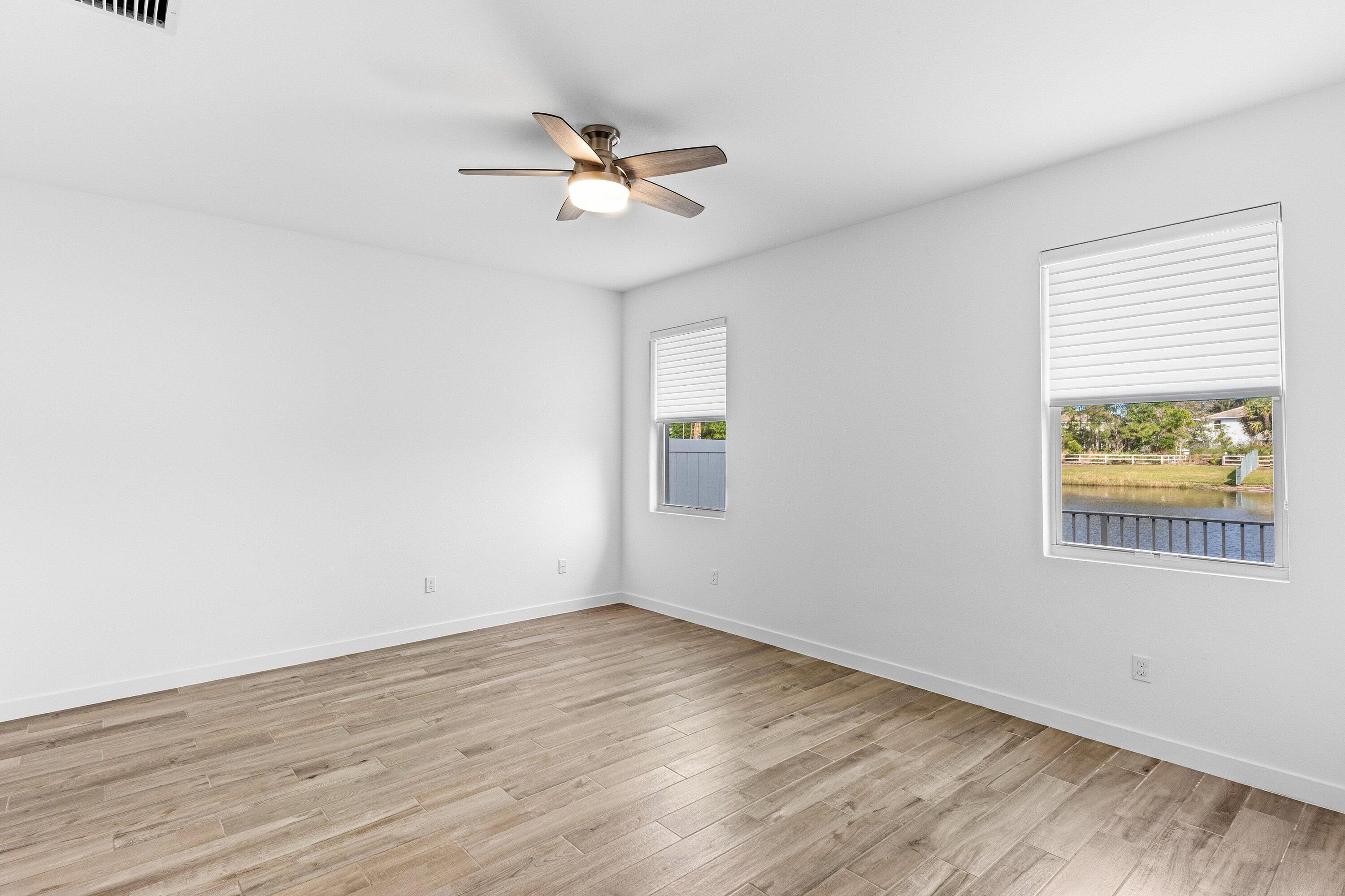 18446 Claybrook Street Jupiter, FL 33458 - Photo 10 of 25 a view of an empty room with wooden floor and a window