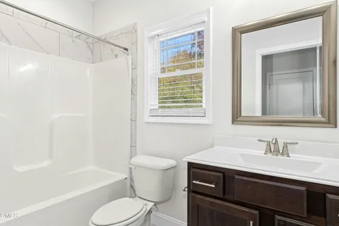 a bathroom with a sink toilet vanity and tub