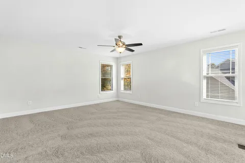 an empty room with a window and a ceiling fan