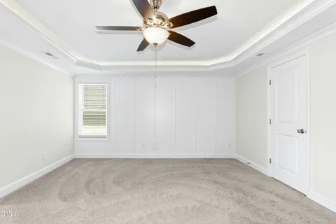 an empty room with a window and a ceiling fan