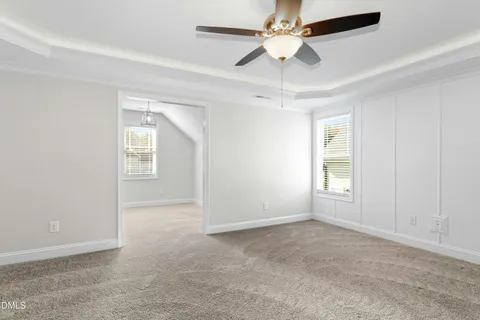 an empty room with windows and fan