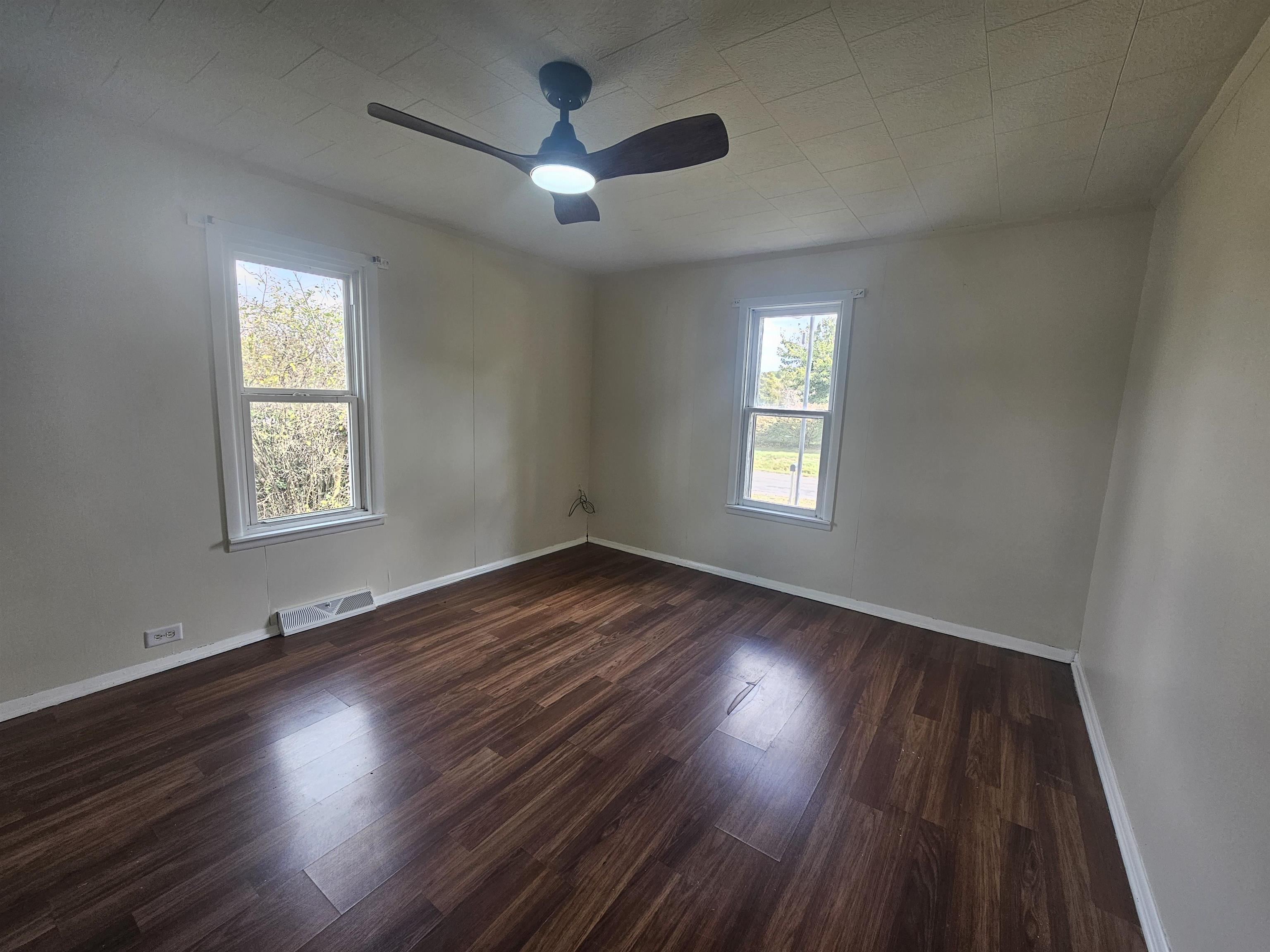 11115 Lamaster Road Marion, IL 62959 - Photo 22 of 26 an empty room with wooden floor chandelier fan and windows