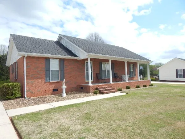 a front view of a house with a yard and seating space