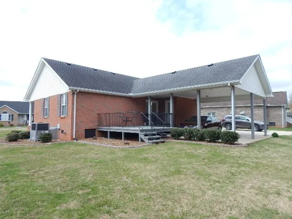 a view of a house with a yard and sitting area