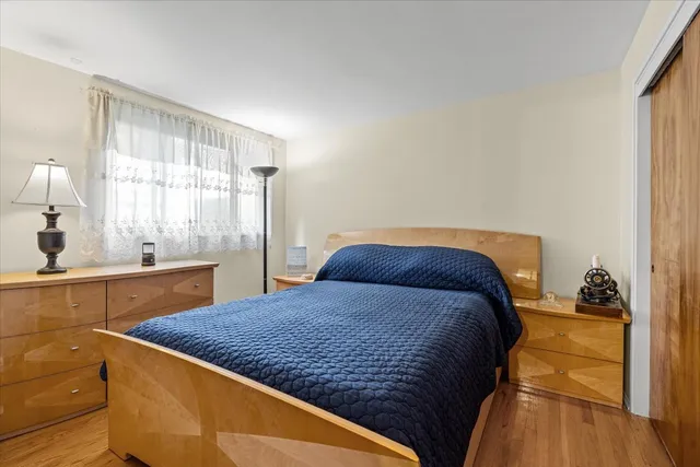 a bedroom with a bed and dresser with mirror