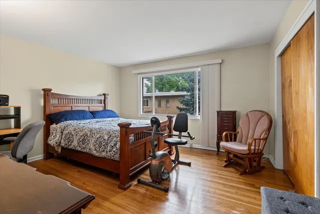 a bedroom with a bed a chair and a large window