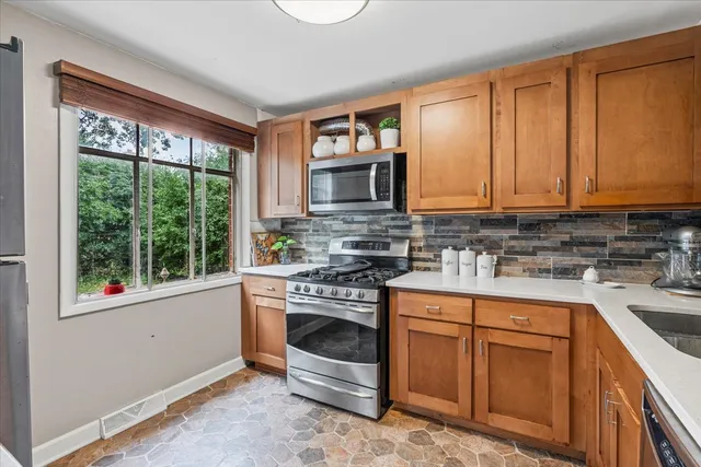 a kitchen with stainless steel appliances granite countertop a stove a sink and a microwave