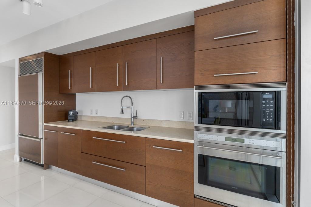 485 Brickell Avenue, Unit 2210 Miami, FL 33131 - Photo 12 of 71 a kitchen with stainless steel appliances granite countertop a sink stove and microwave