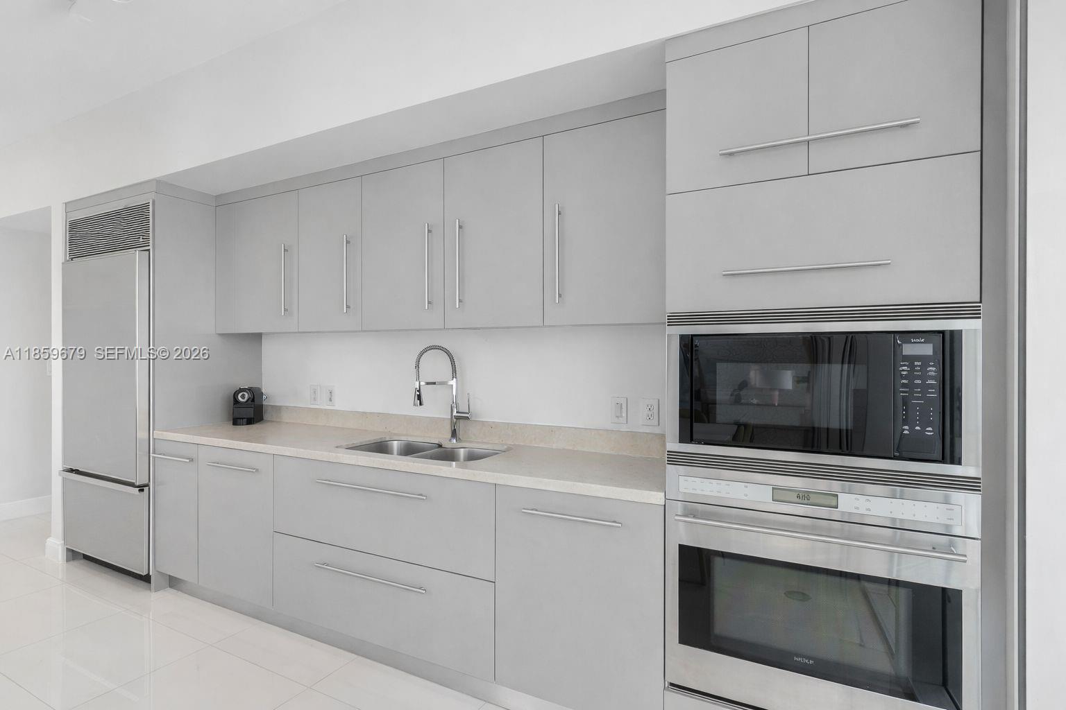 485 Brickell Avenue, Unit 2210 Miami, FL 33131 - Photo 13 of 71 a kitchen with white cabinets stainless steel appliances and sink
