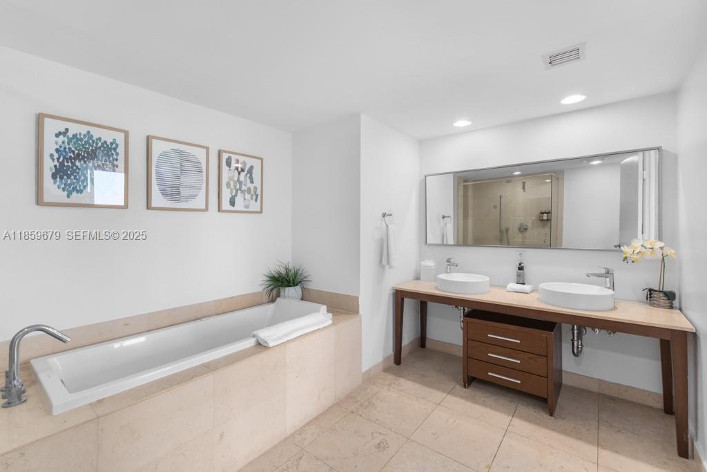 485 Brickell Avenue, Unit 2210 Miami, FL 33131 - Photo 19 of 66 a bathroom with a tub sink and mirror
