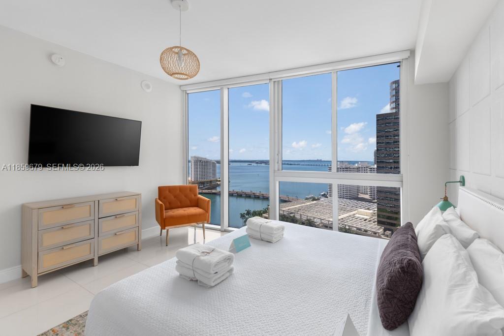 485 Brickell Avenue, Unit 2210 Miami, FL 33131 - Photo 20 of 71 a bedroom with furniture and a flat screen tv