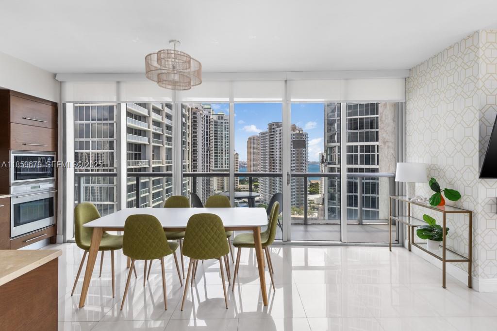 485 Brickell Avenue, Unit 2210 Miami, FL 33131 - Photo 7 of 66 a view of a dining room with furniture a potted plant and wooden floor