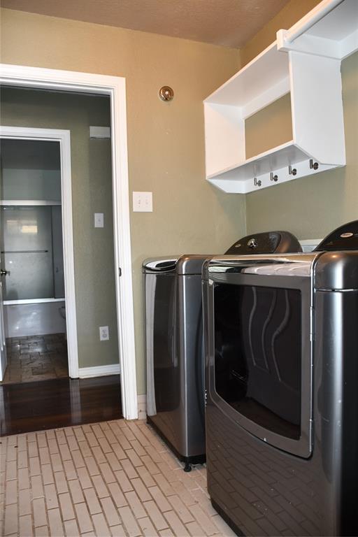 6241 Peach Tree Drive Midlothian, TX 76065 - Photo 14 of 19 Laundry area featuring brick-patterned tile flooring, a white shelving unit with integrated hooks, and a warm neutral wall color