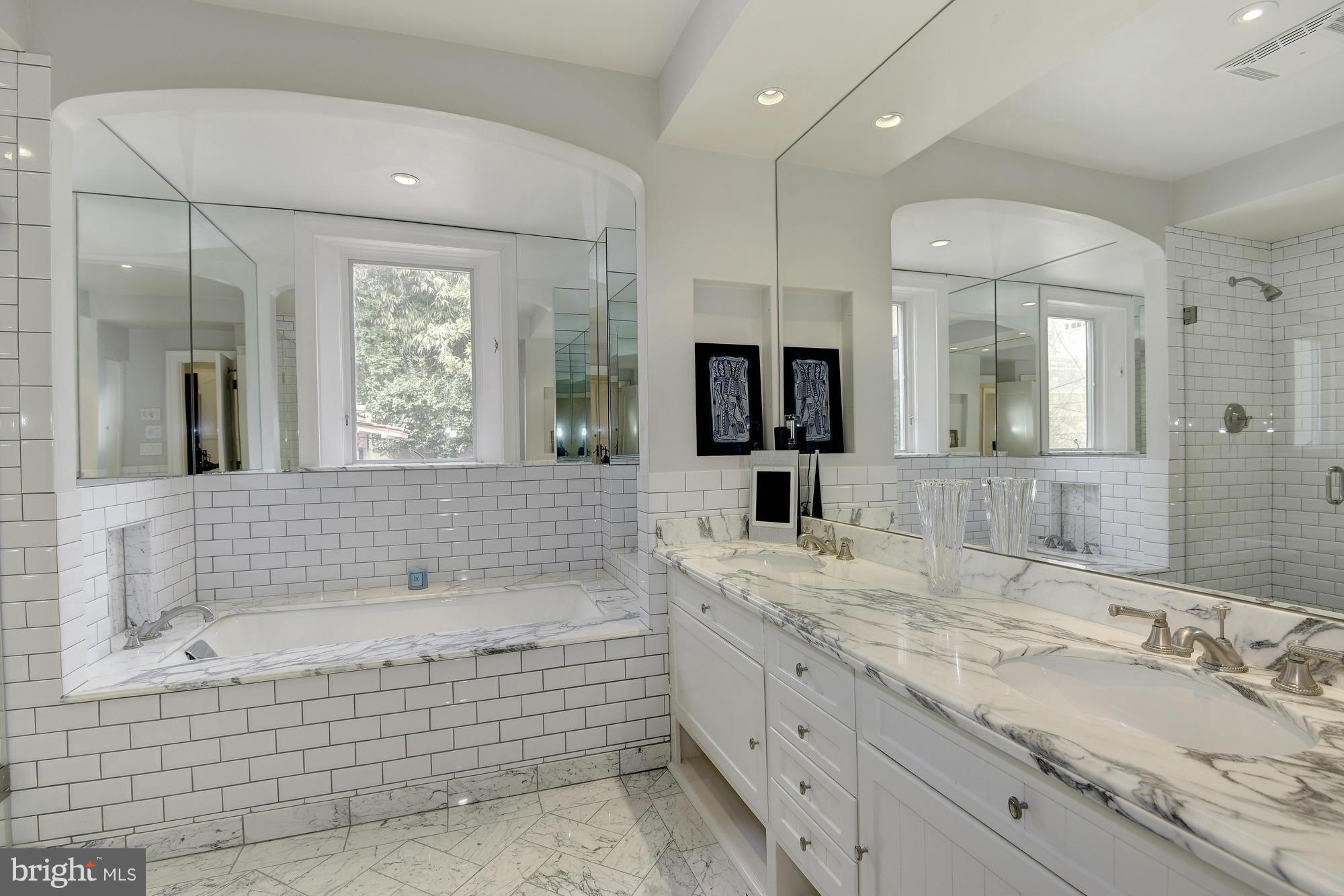 2441 California Street Northwest Washington, DC 20008 - Photo 11 of 22 a bathroom with a bathtub a double vanity sink a window and a mirror