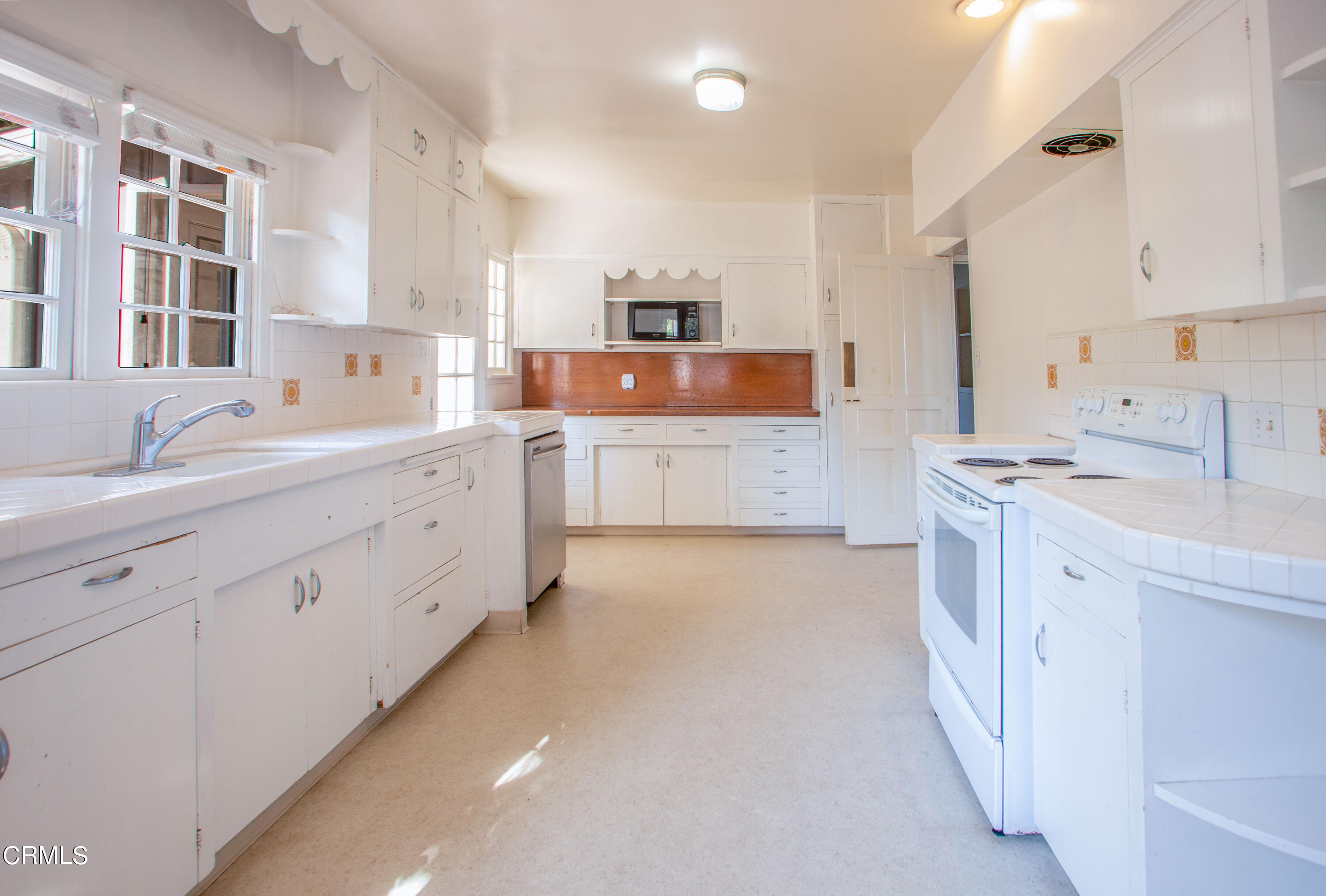 2971 Foothill Road Ventura, CA 93003 - Photo 8 of 25 a large white kitchen with stainless steel appliances sink and cabinets