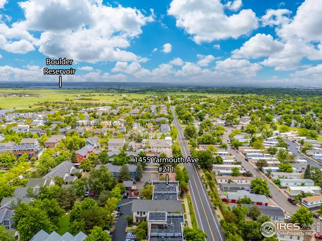 an aerial view of a city with lots of residential buildings and mountain view in back