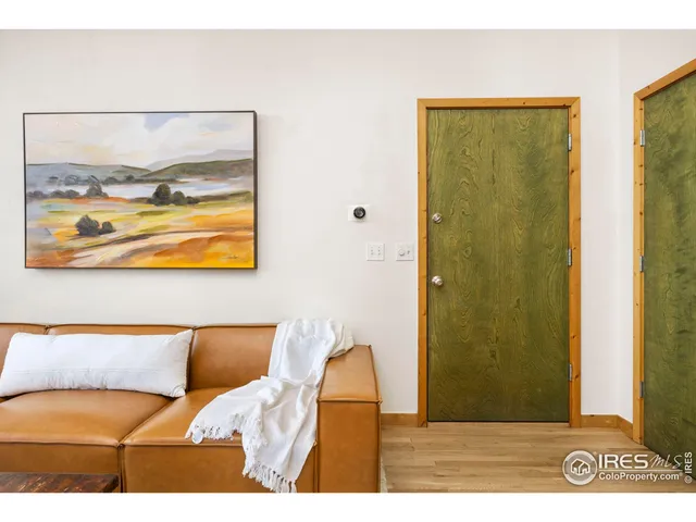 a bedroom with a bed and painting on the wall