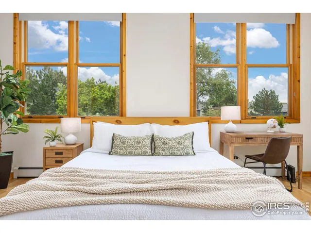 a bedroom with a bed and a large window