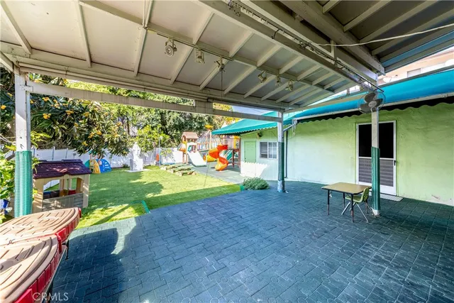 a backyard of a house with barbeque oven table and chairs