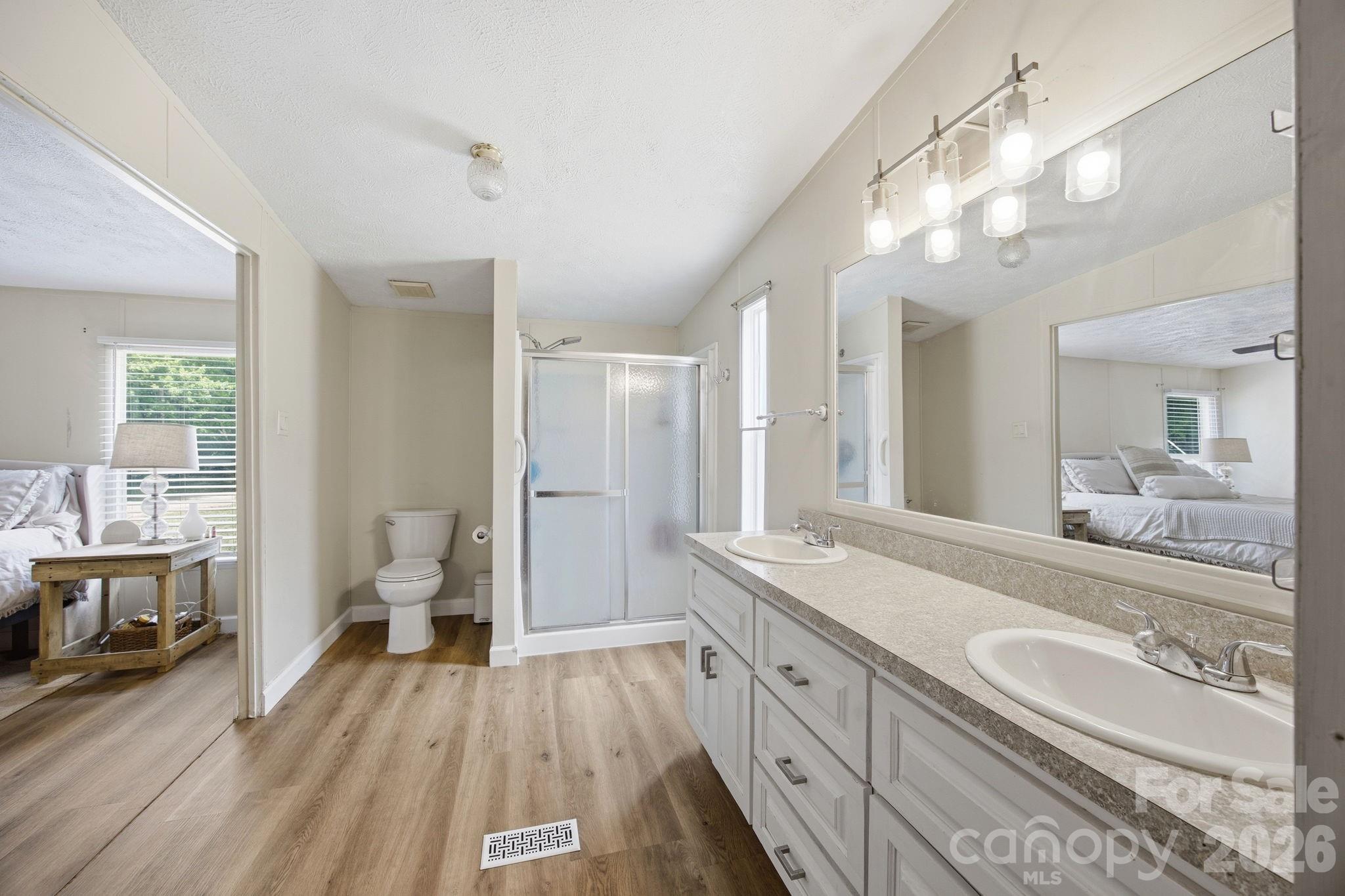 675 Overcash Road Salisbury, NC 28147 - Photo 27 of 48 a spacious bathroom with a granite countertop double vanity sink a mirror and a shower