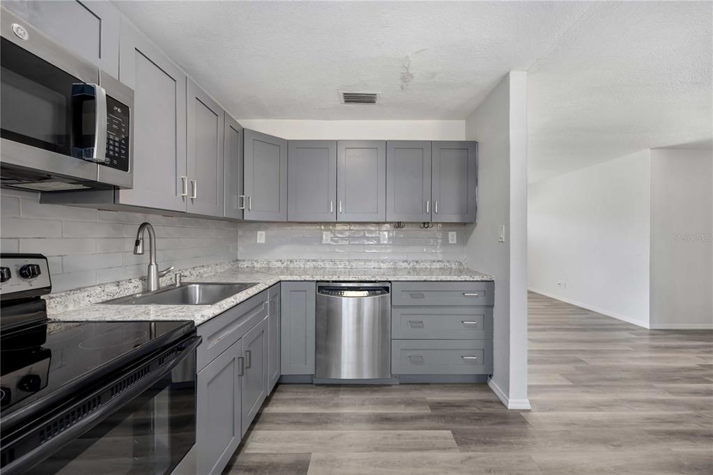 6319 Lafayette Road Bradenton, FL 34207 - Photo 12 of 30 a kitchen with stainless steel appliances granite countertop a sink stove and microwave