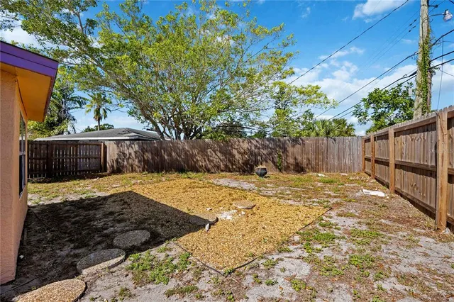a view of a backyard with wooden fence