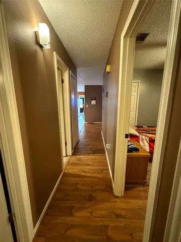 a view of a hallway with wooden floor and stairs