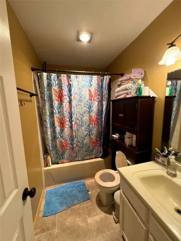 a bathroom with a sink mirror vanity and toilet