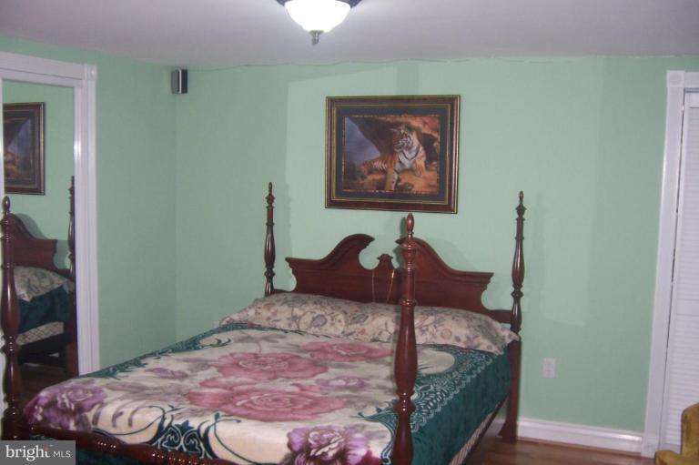 10212 Portland Road Silver Spring, MD 20901 - Photo 13 of 13 a bedroom with a bed and a painting on the wall