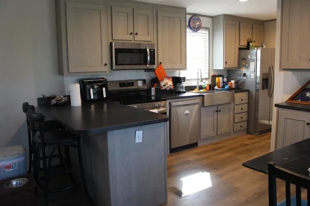 a kitchen with stainless steel appliances granite countertop a stove a sink dishwasher a microwave oven with granite countertops and cabinets