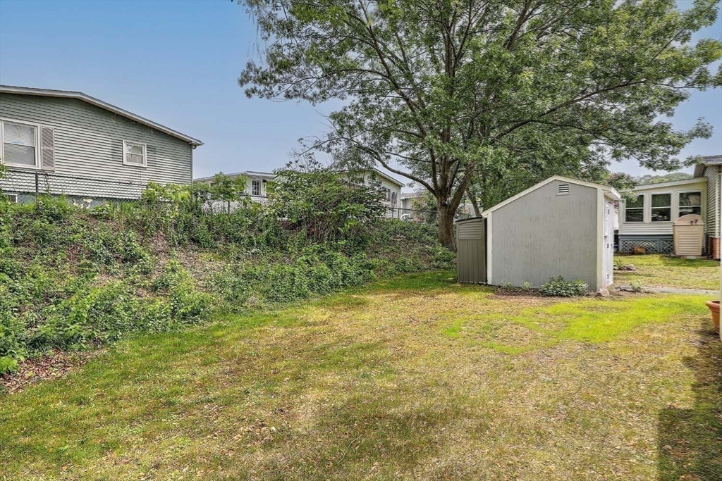 7 Queens Road Attleboro, MA 02703 - Photo 23 of 33 a backyard of a house with large trees and plants