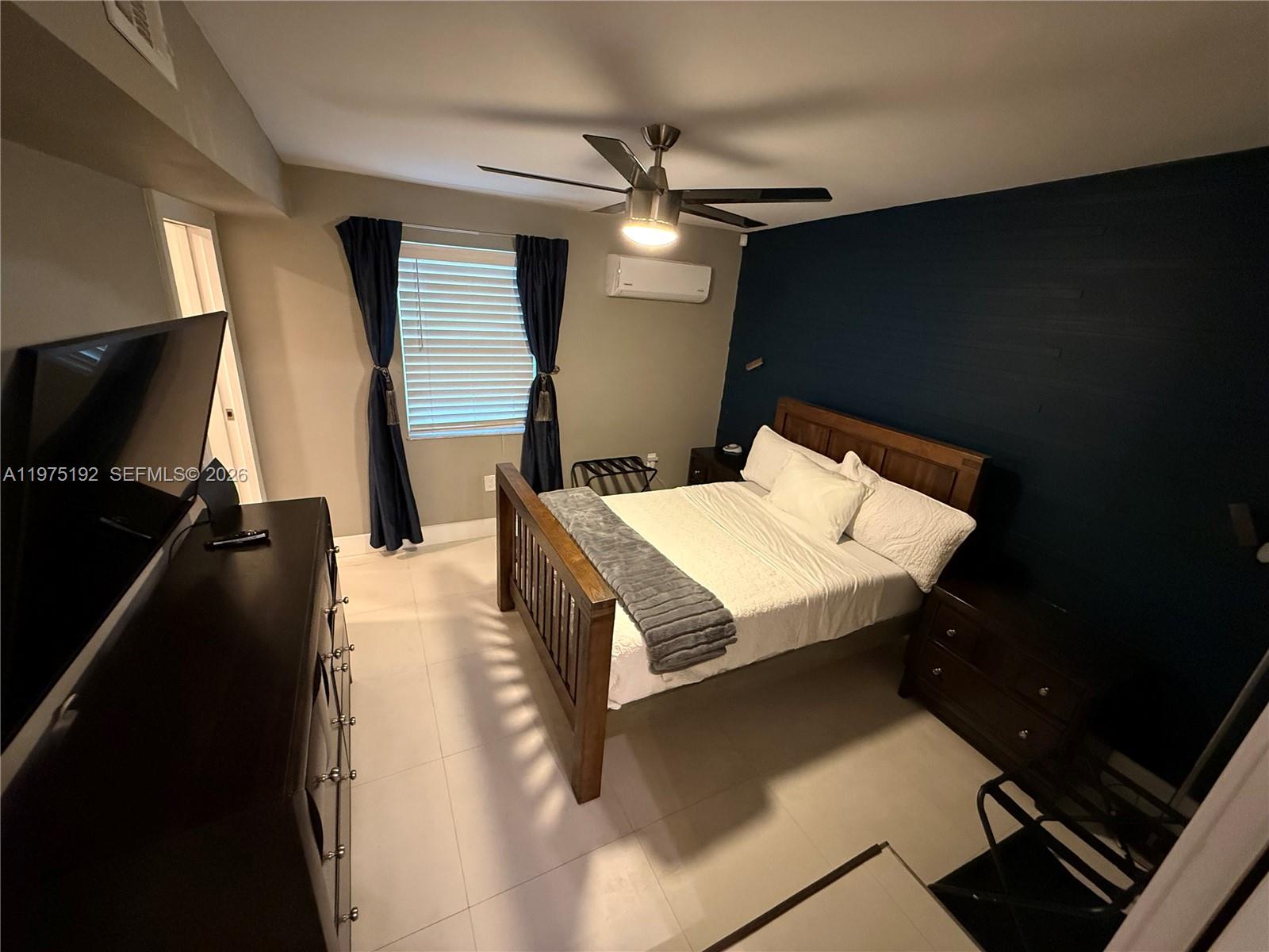 4850 Southwest 4th Street Miami, FL 33134 - Photo 11 of 28 a bedroom with a bed and a flat tv screen on dresser