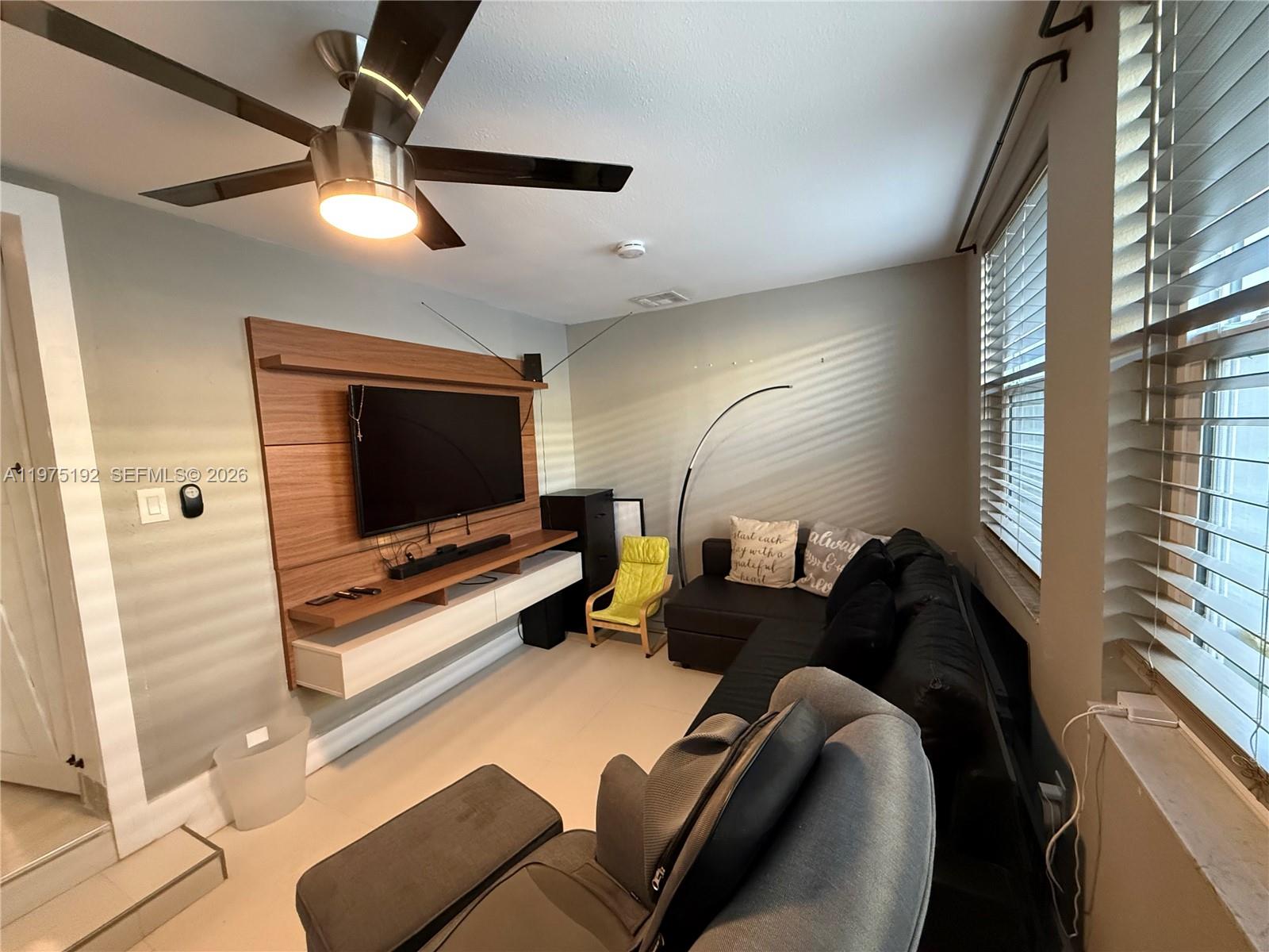 4850 Southwest 4th Street Miami, FL 33134 - Photo 6 of 28 a living room with furniture and a flat screen tv