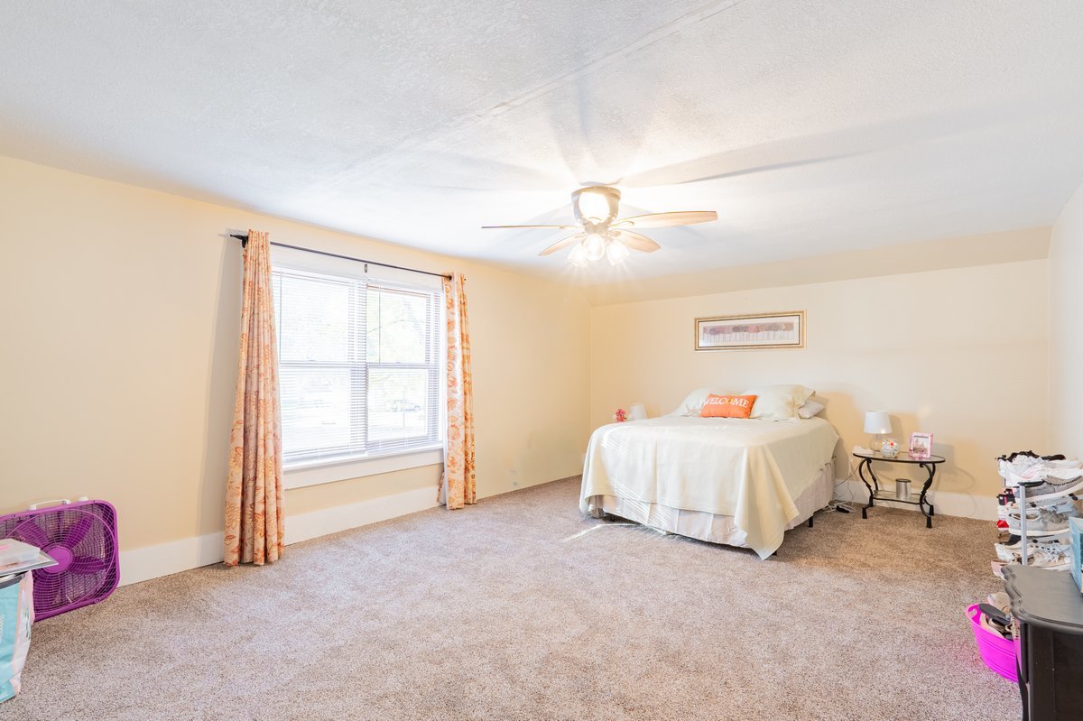 1206 East Main Street Clinton, IL 61727 - Photo 15 of 28 a spacious bedroom with a bed and a chandelier