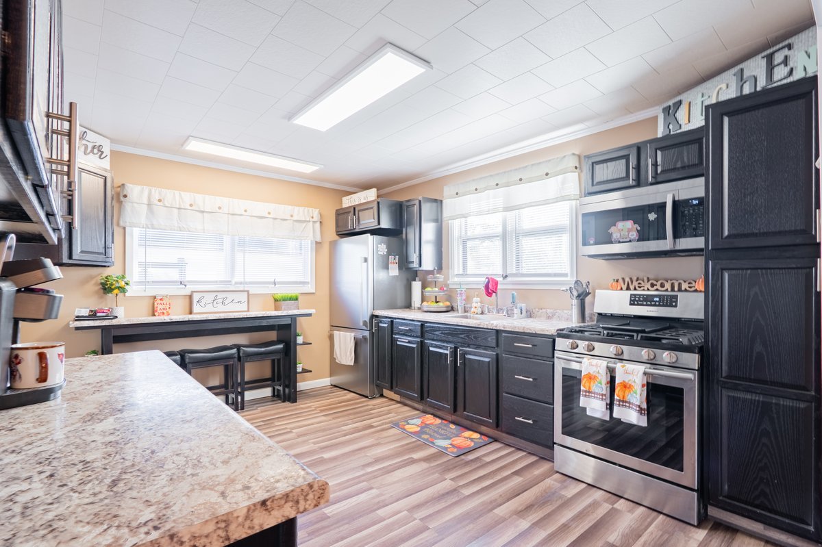 1206 East Main Street Clinton, IL 61727 - Photo 10 of 28 a kitchen with stainless steel appliances granite countertop a stove top oven a sink dishwasher and wooden cabinets with wooden floor