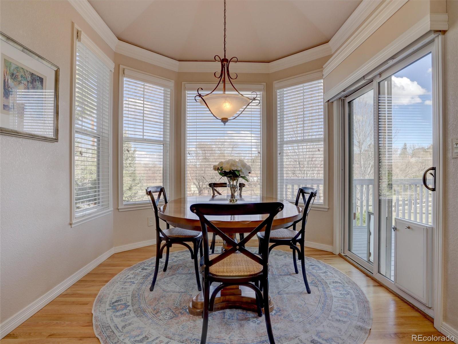 18288 East Caley Place Aurora, CO 80016 - Photo 11 of 50 a dining room with furniture a chandelier and wooden floor