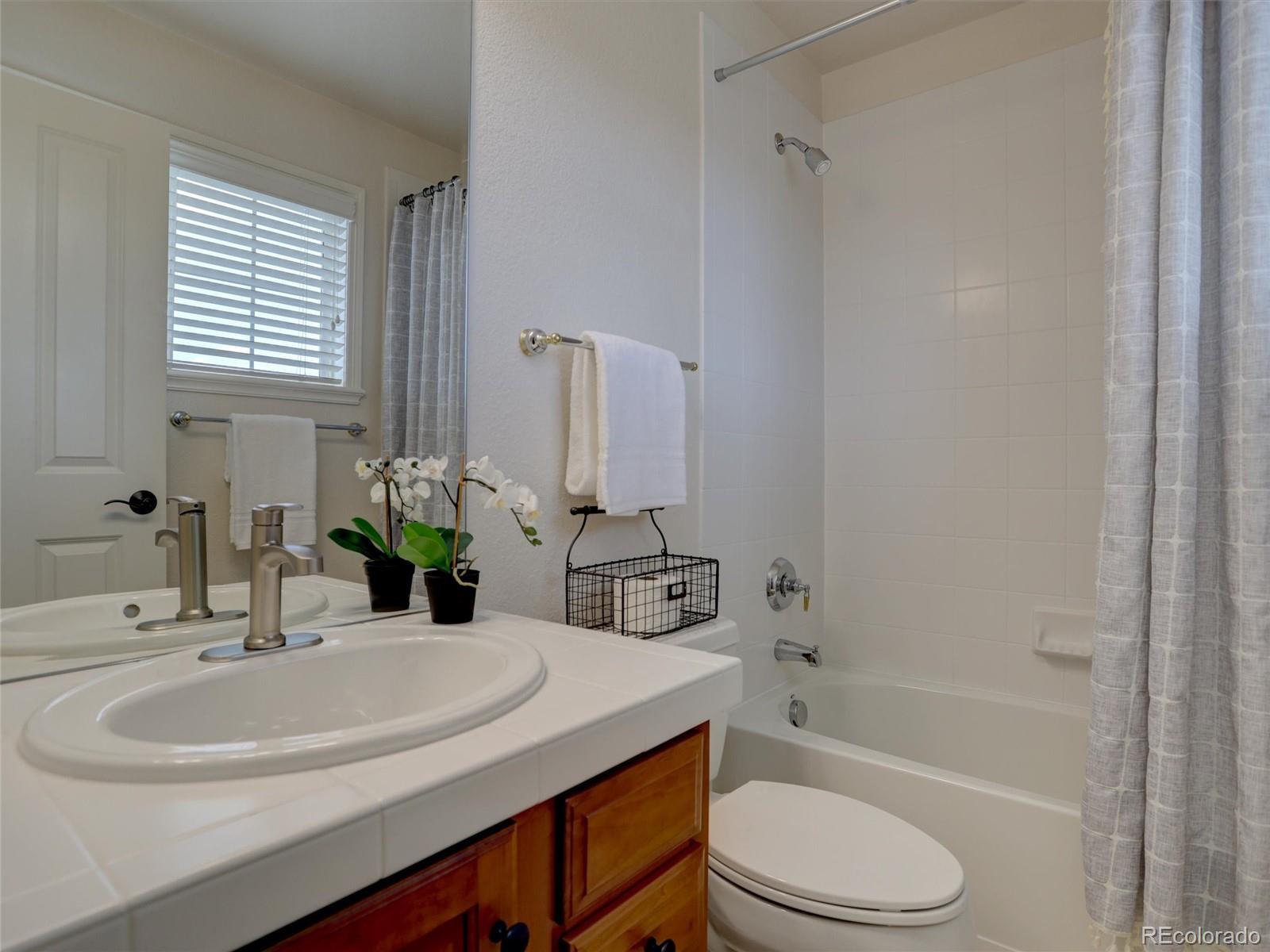 18288 East Caley Place Aurora, CO 80016 - Photo 22 of 50 a bathroom with a sink toilet a mirror and shower