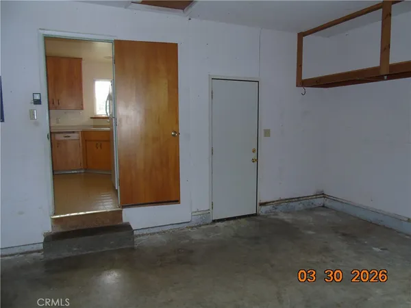 an empty room with wooden floor and a ceiling fan