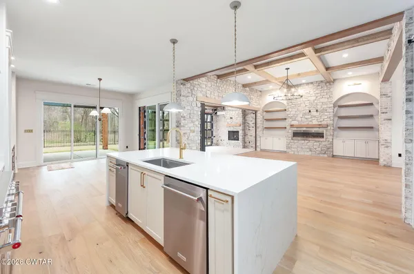 a kitchen with kitchen island a sink stainless steel appliances and cabinets