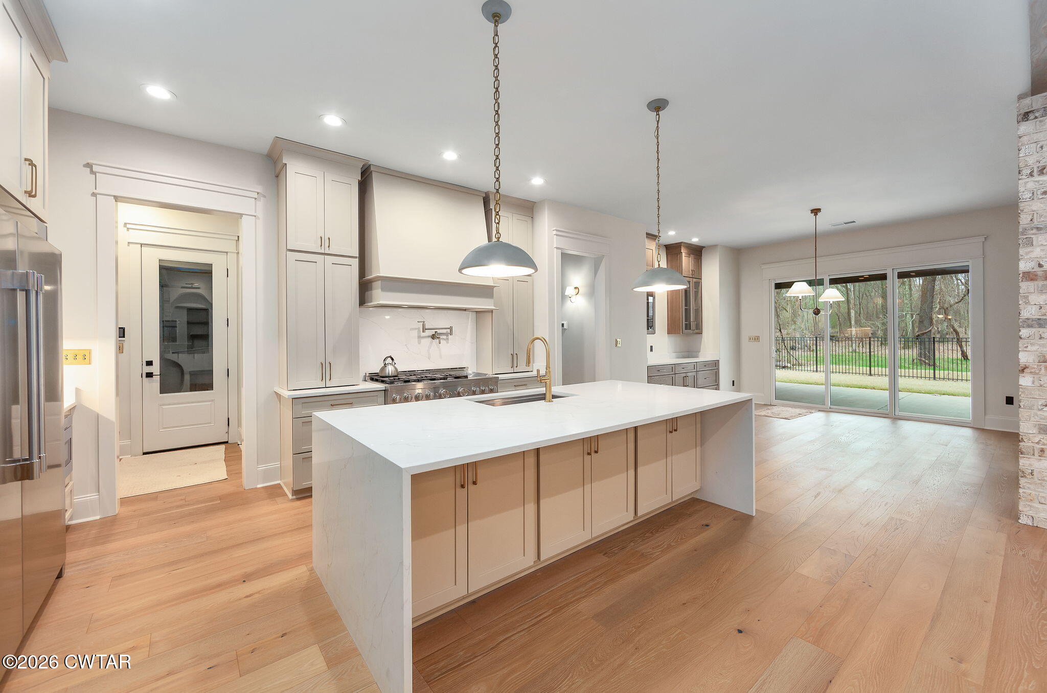 115 Buckingham Cove Jackson, TN 38305 - Photo 15 of 58 a large kitchen with kitchen island a stove a sink a refrigerator and a wooden floor
