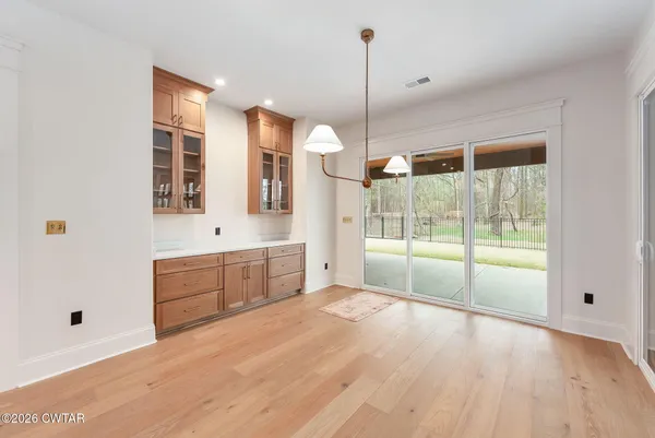 a view of an empty room with glass door and windows
