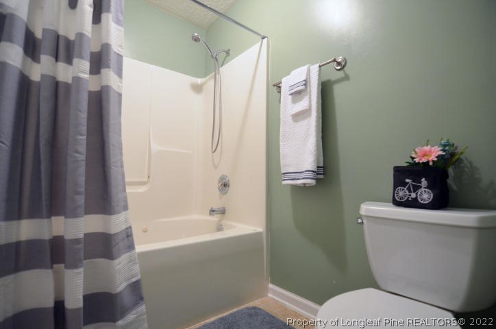 526 Riverwind Drive Spring Lake, NC 28390 - Photo 20 of 29 a white toilet sitting next to a bathroom sink and tub